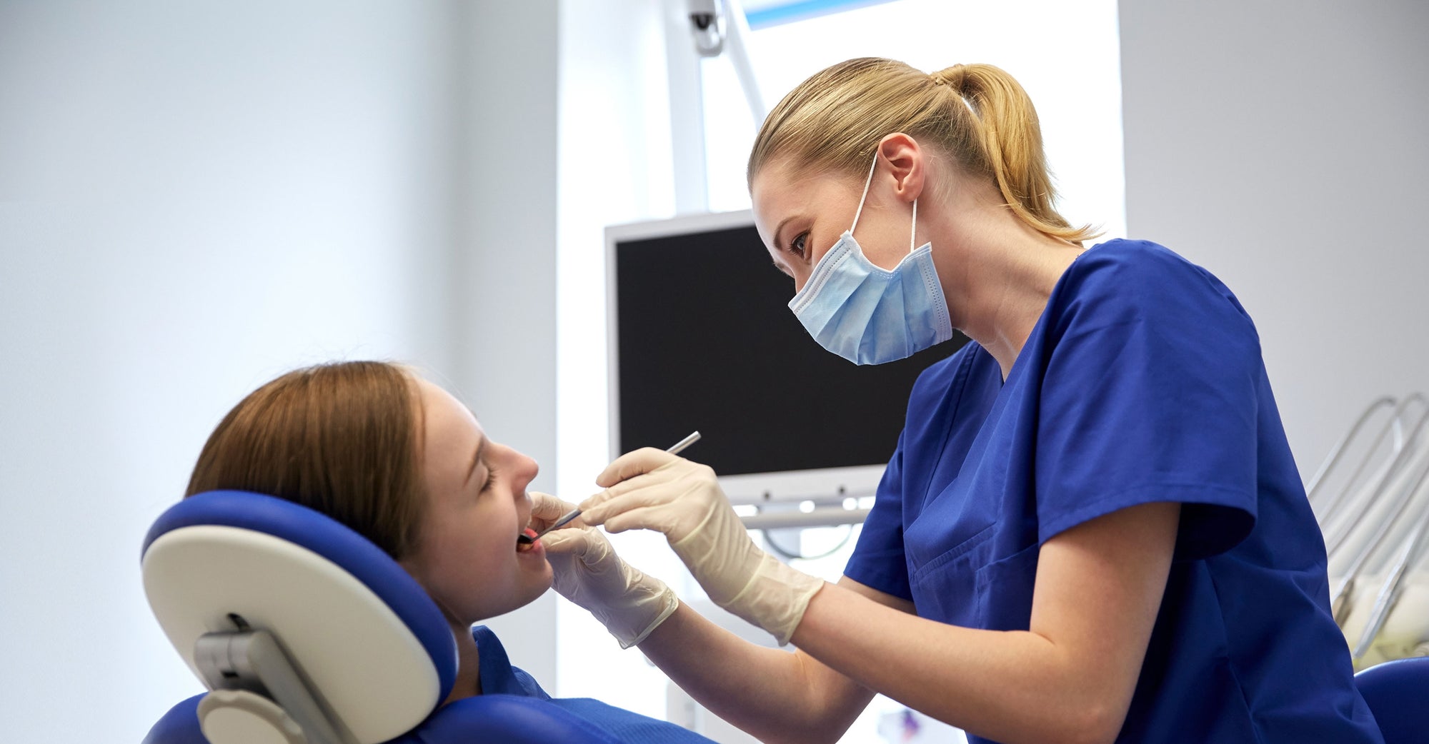 Image of dental professional performing procedure on woman