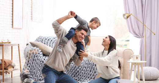 parents with child playing in living room