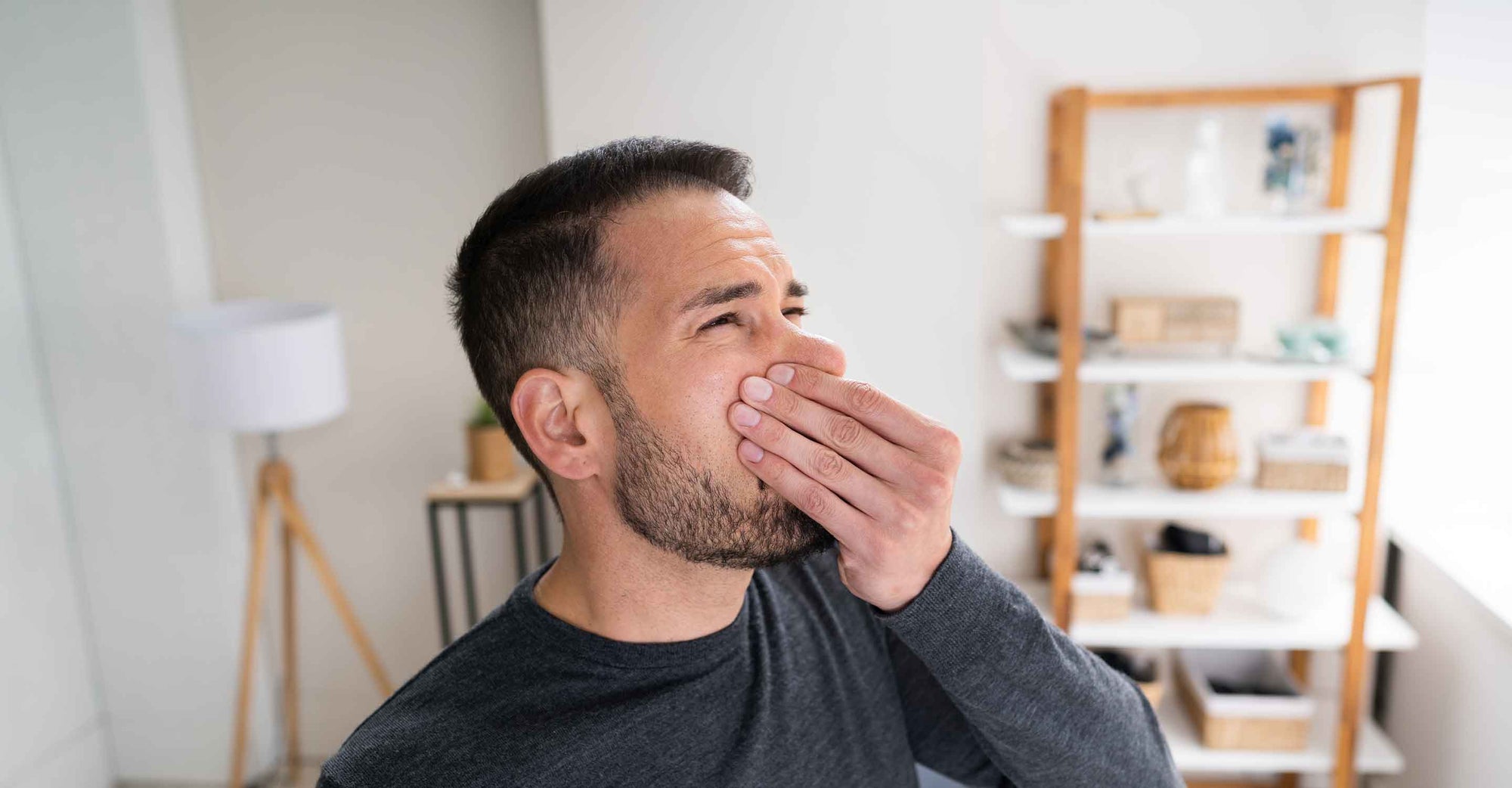 Man in home holding nose