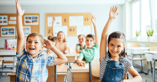 Children raising hands in class