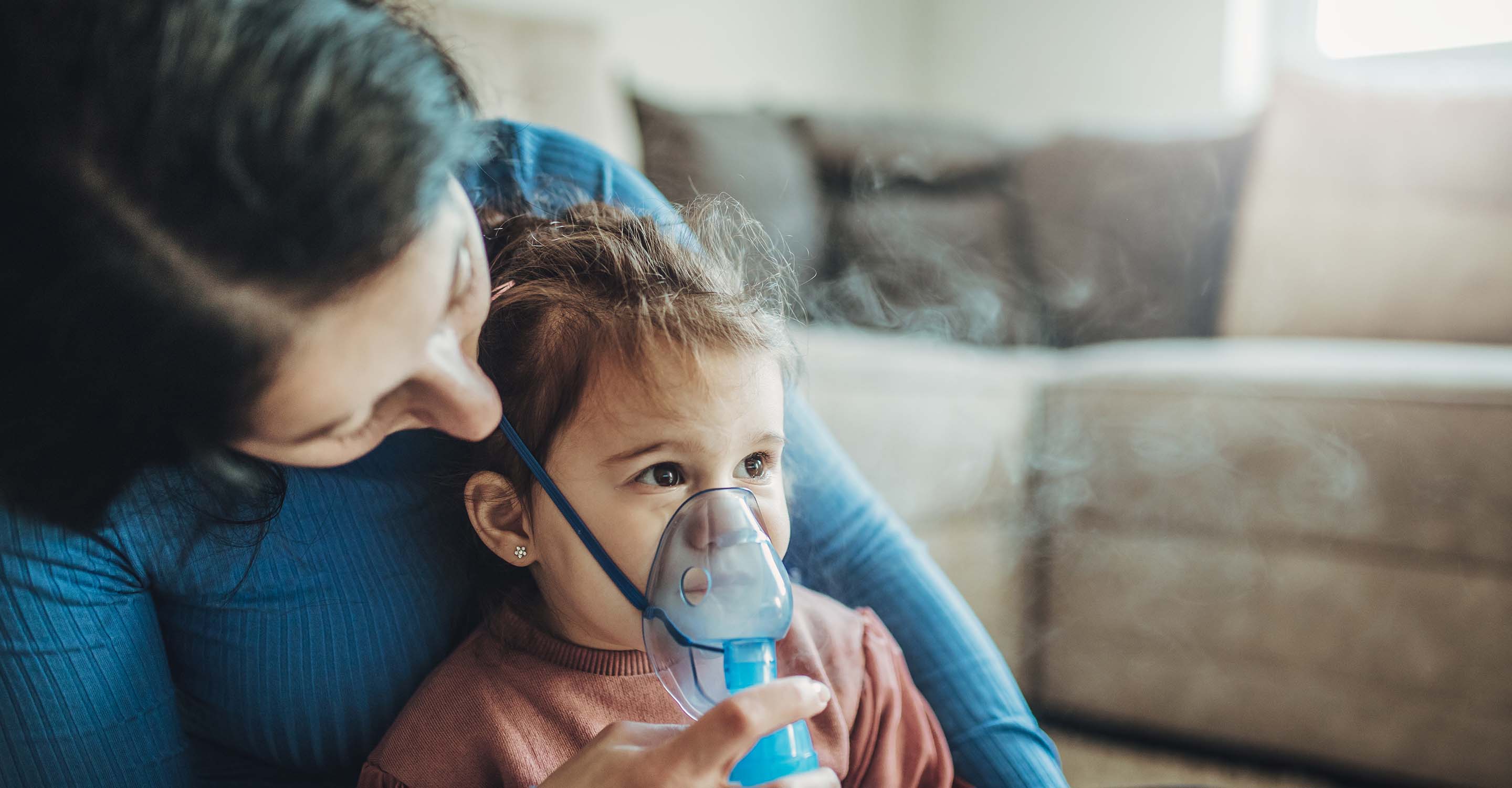 Mother helps her little girl breath with an oxygen apparatus