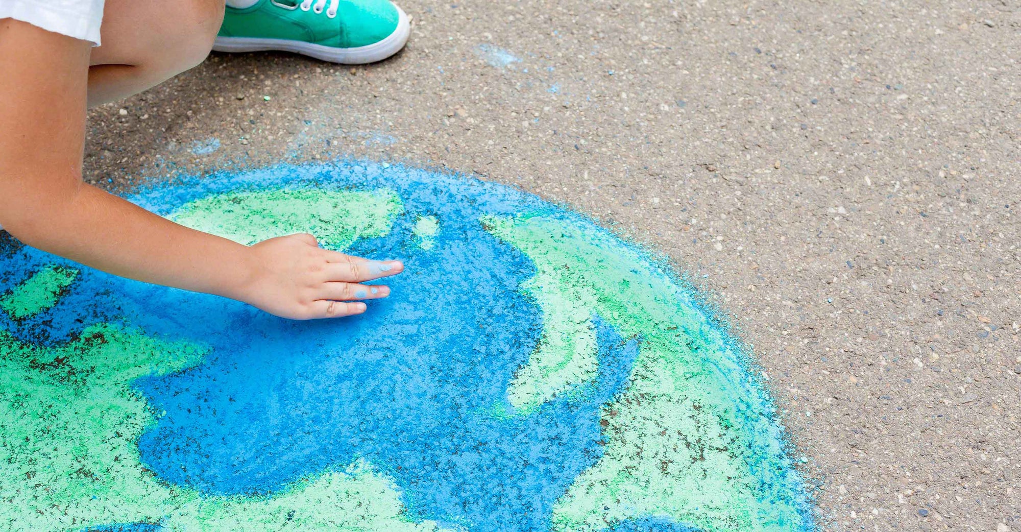 child with chalk drawing Earth