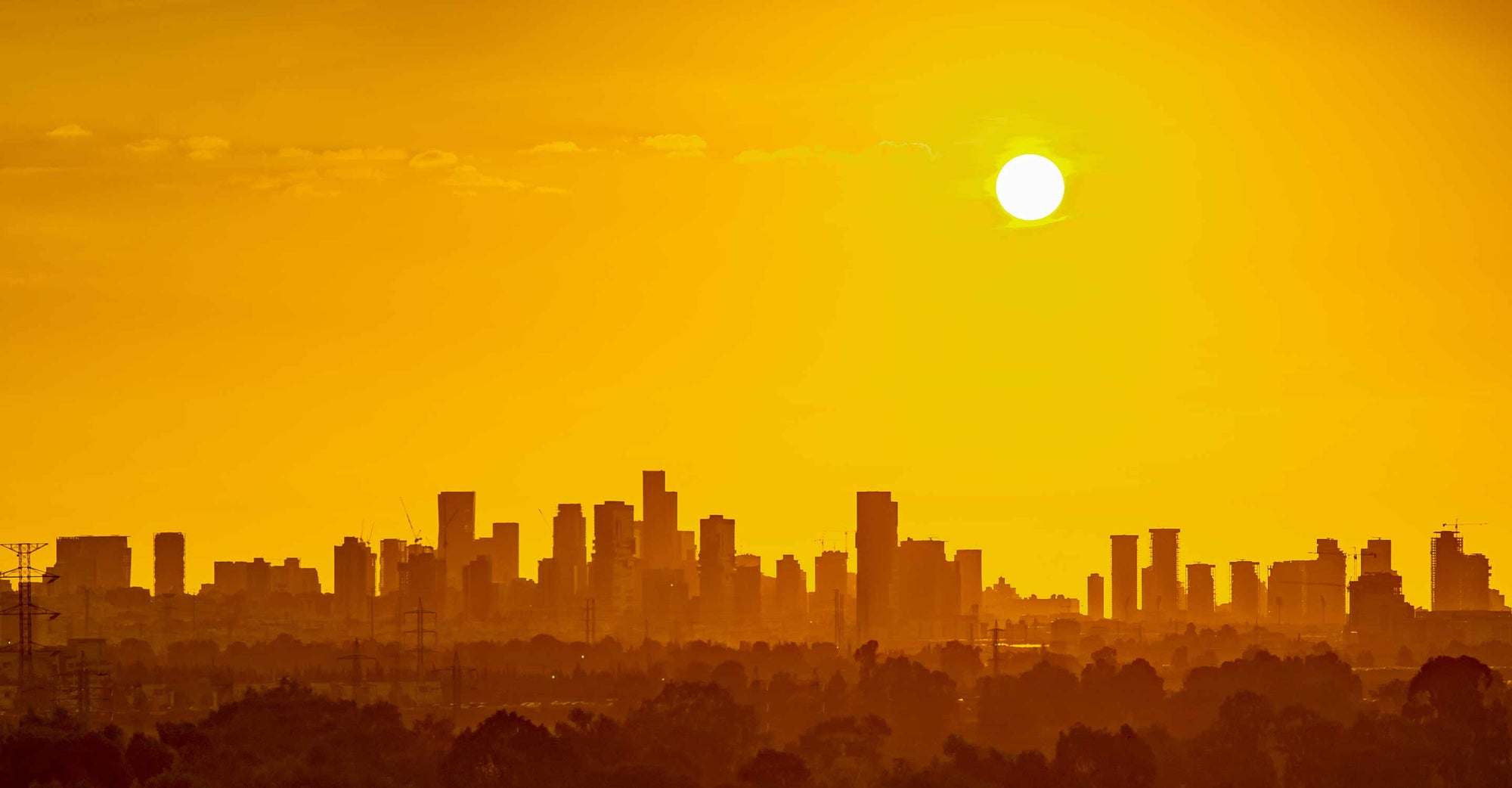 The sun rises over a city enduring a heat wave.