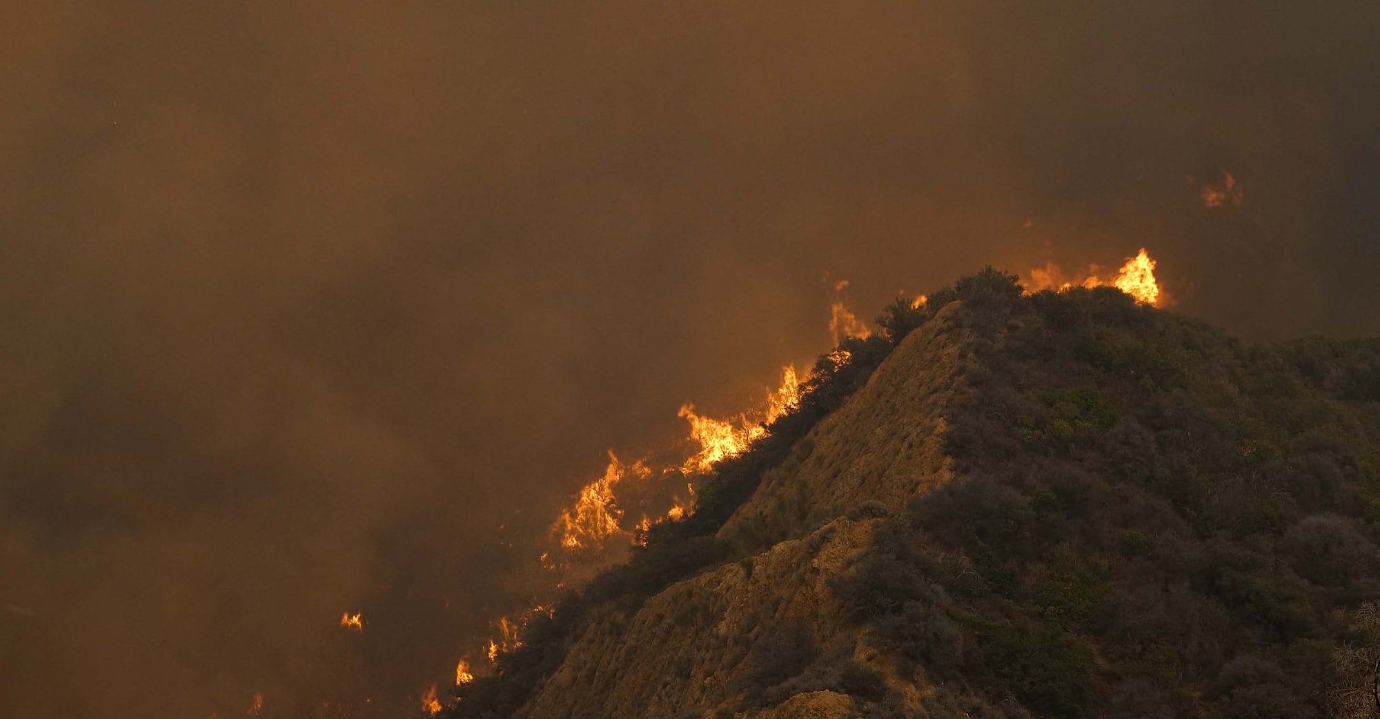 Fire burning on a hillside.