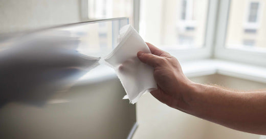 man cleaning the dust from the tv